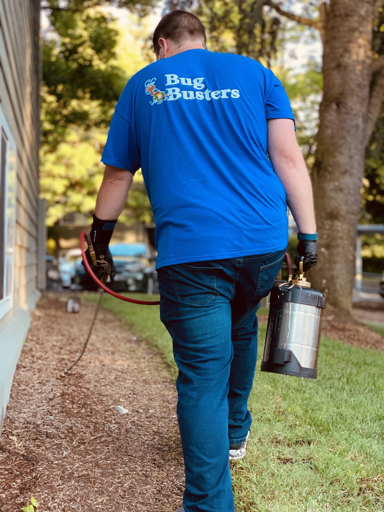 Bug Busters technician in blue uniform treating a foundation
